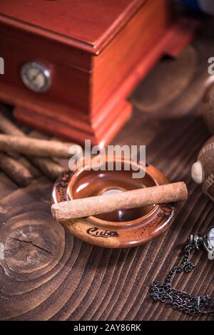 Cuban cigar in ashtray on wooden table Stock Photo