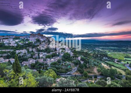 Rising sun over valley with Gordes town Stock Photo