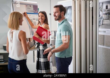 consideration, communication, buying, choosing, discussing, making decision concept. young,  couple considering what color to chose for their home in Stock Photo