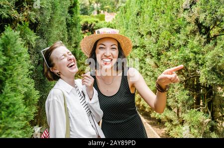 Two women friends laughing and hugging outdoors at labyrinth Stock Photo