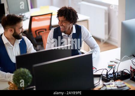 two colleagues talking and laughing in modern office. funky business concept Stock Photo