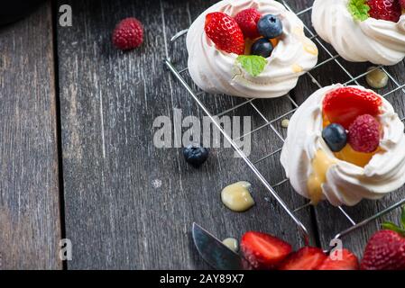 Decorating homemade pavlova meringue with berries fruit Stock Photo