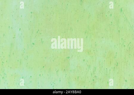 Textured metal surface carelessly colored green paint and faded in the sun in pale gray with rusty specks. Stock Photo