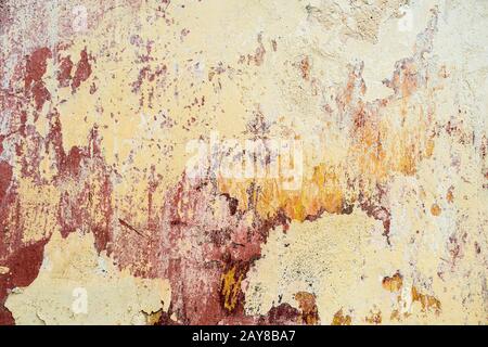 Textured background of multi-layer flaking paint on the wall. Mixing different colors of paints in the cleaved layers on the sur Stock Photo