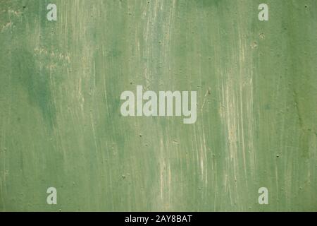 Textured metal surface carelessly colored green paint and faded in the sun in pale gray with rusty specks. Stock Photo
