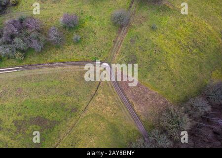 tractor path in the winter from above with a curve from far above Stock Photo