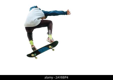 A teenager skateboarder jumps an ollie on an isolated white background. The concept of street sports and urban culture Stock Photo