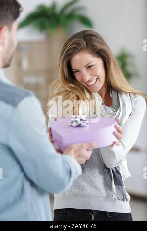 cute joyful curly woman happy to recieve heart gift Stock Photo