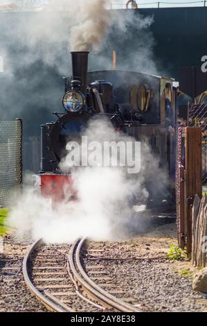 Departure of a steam locomotive in a cloud of smoke and steam Stock Photo