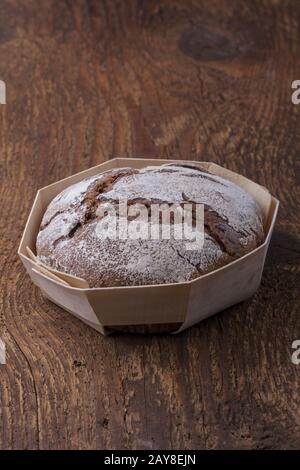 Whole grain rye bread on dark wood Stock Photo