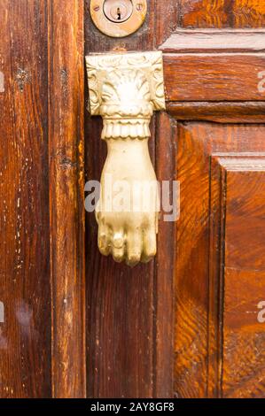 White door knocker shaped like a hand Stock Photo