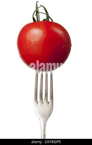 fresh tomato on an old silver fork Stock Photo