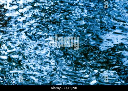 Abstract sparkling blue water surface with small waves as texture / background Stock Photo