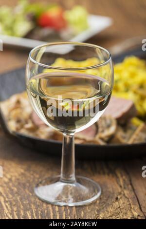 White wine and Swabian pork fillet with spaetzle on wood Stock Photo