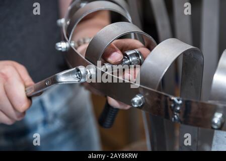 Craftsmen fasten screws and nuts - Detail Stock Photo