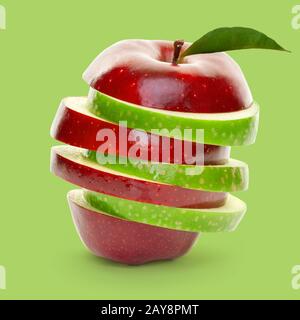 Mixed green and red apple slices piled up and isolated on green background Stock Photo