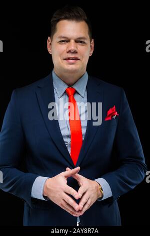 Portrait of confident handsome businessman thinking on black background Stock Photo
