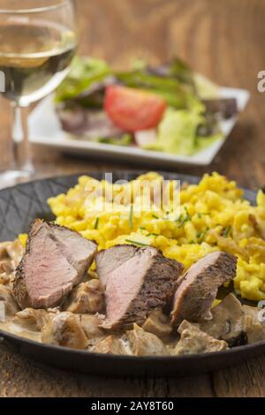 Swabian pork fillet with spaetzle and wine Stock Photo