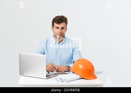 Handsome male construction engineer working in the office with laptop Stock Photo