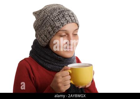 A young woman drinks a cup of hot tea in the winter time isolated on white background. Stock Photo