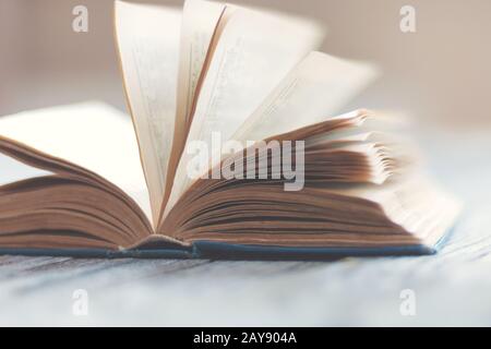 Open paper book on wooden table, retro style education and  literature background Stock Photo