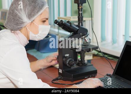 Woman scientist looking in a microscope Stock Photo
