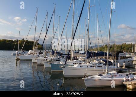 Luxury Sail Yachts moored along a Pier  in Bowness-on-Windermere on Lake WIndermere in Cumbria Stock Photo