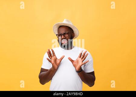 Closeup portrait of shocked mad young man raising hand up to say no stop right there, isolated on yellow background. Negative em Stock Photo