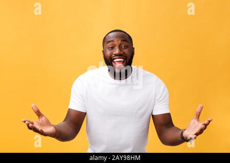 Amazed young African American hipster wearing white t-shirt holding hands in surprised gesture, keeping mouth wide open, looking Stock Photo