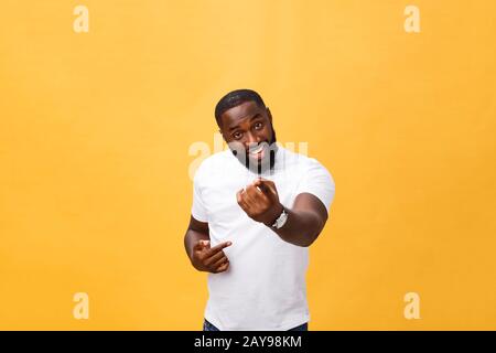 Funny young African customer smiling happily and pointing his index fingers at camera as if choosing you and inviting to big sal Stock Photo