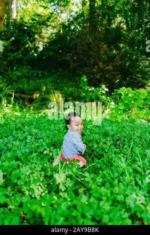 Closeup portrait of a baby boy looking over his shoulder outdoors Stock Photo