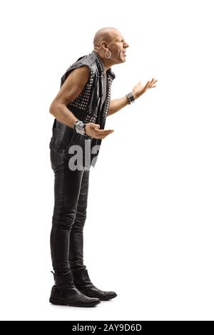 Full length profile shot of an angry punk in leather clothes gesturing with hands isolated on white background Stock Photo