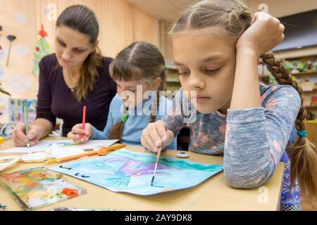 The teacher helps the students in drawing class Stock Photo - Alamy