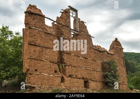 Brick wall with adobe clay plaster  of ruined old rural country house Stock Photo