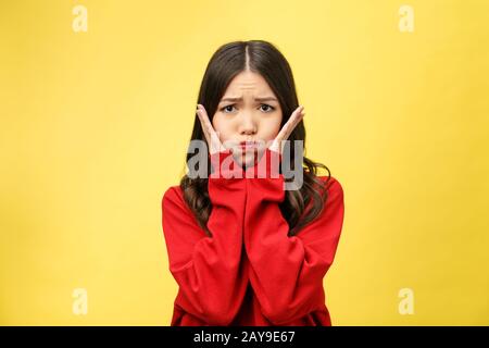 Portrait of good looking young attractive woman has curious gaze at camera, keeps finger on chin, listens attentively interlocut Stock Photo