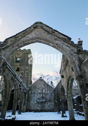 the medieval ruined church in heptonstall covered in snow showing arches and columns and blue sky Stock Photo