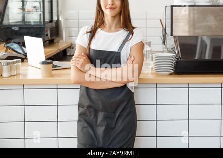 Coffee Business owner Concept - attractive young beautiful caucasian barista in apron smiling at camera in coffee shop counter. Stock Photo