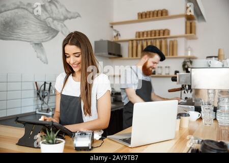 Coffee Business Concept - beautiful caucasian bartender barista or manager Posting order in digital tablet menu at modern coffee Stock Photo