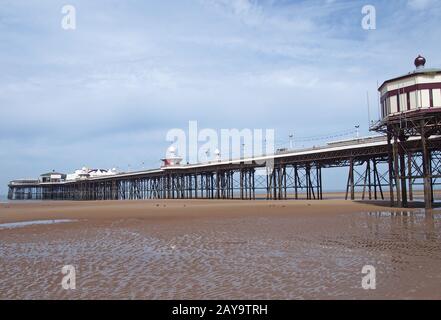 view of the historic victorian north pier in blackpool with the kiosks and buildings with the beach Stock Photo