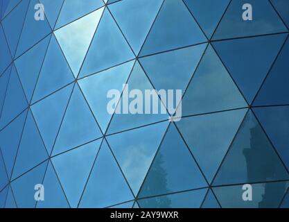 angular geometric patterned mirrored windows panes reflecting the sky and clouds Stock Photo