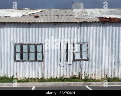 full frame close up of a shabby old dilapidated corrugated iron building with with closed painted ov Stock Photo
