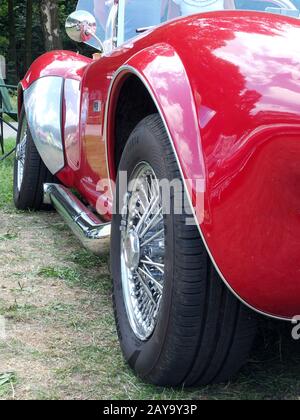 side view of the exhaust and wheels of a rare Vintage AC Cobra Sports Car on display Stock Photo