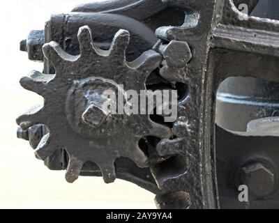 a close up of old worn black painted large cog wheels with gear teeth  industrial machinery Stock Photo