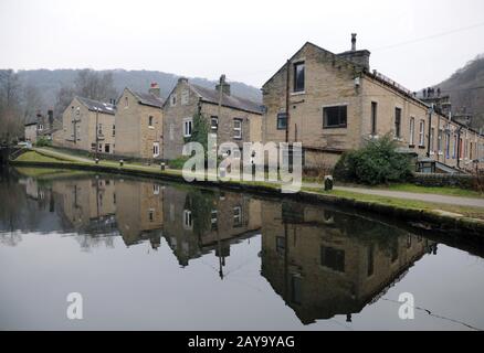 streets of terraced houses alongside the rochdale canal in hebden bridge with reflections in the wat Stock Photo