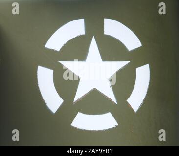 a white US army star in an invasion circle stencilled on an olive green painted military vehicle Stock Photo