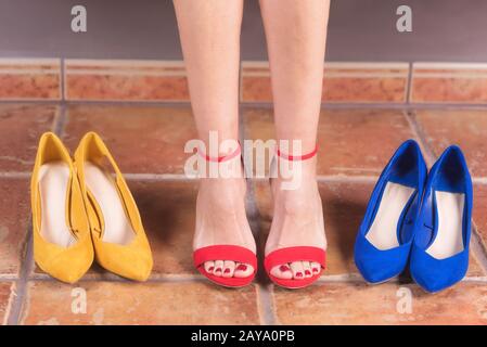 Woman with perfect slim legs, trying on different high heel shoes. Shopping concept. Stock Photo