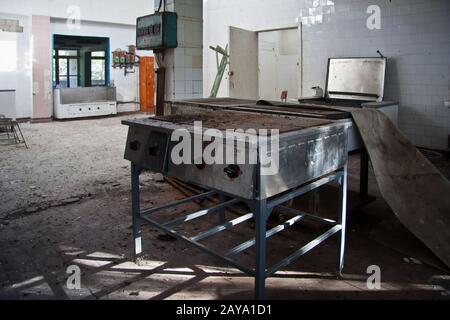 Abandoned and ruined kitchen of closed factory canteen or restaurant Stock Photo