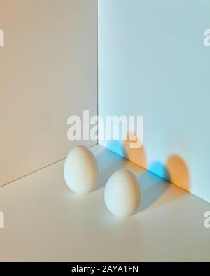 The composition of eggs on a gray-blue double background with copy space and multicolored shadows. Easter concept. Stock Photo