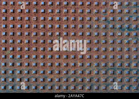 Square shapes on rusted metal surface with patterns and cracks Stock Photo