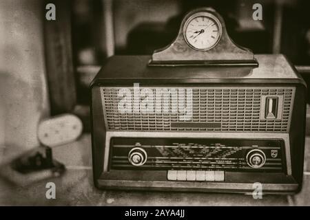 Old vintage radio receiver of the last century with rustic clock on top Stock Photo